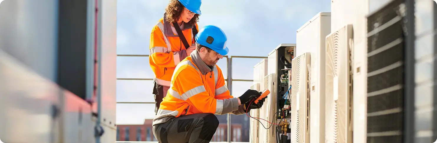 A man and woman technicians doing measurements and maintenance of rooftop equipments.