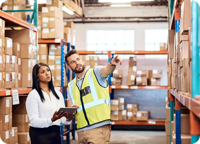 A man and woman discussing in a warehouse