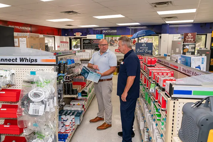 2 men discussing in the shopping aisle of a store